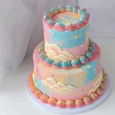 a three tiered cake with stars and clouds on it