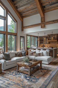 a living room filled with lots of furniture and large windows next to a wooden ceiling