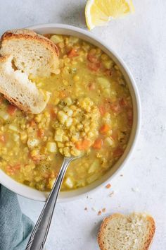 a white bowl filled with soup next to a slice of bread