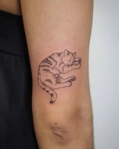 a small cat tattoo on the right arm and leg, it is black and white