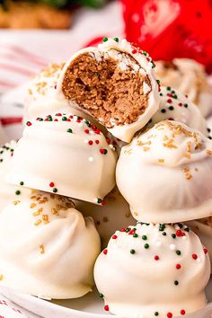 a white plate topped with lots of desserts covered in frosting and sprinkles