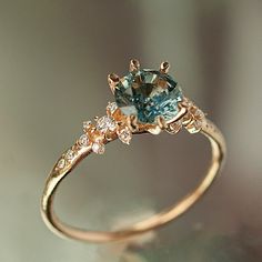 a gold ring with an aqua and white diamond