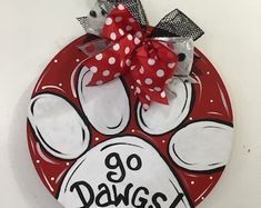 a red and white dog paw with polka dot bow hanging from a hook on a wall