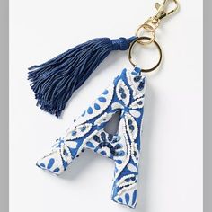 a blue and white keychain with a tassel hanging from it's side