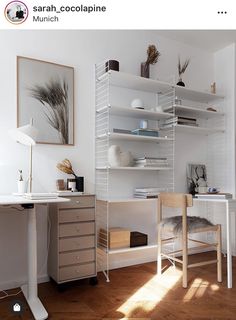 a white desk and chair in a room with wooden flooring, bookshelves and shelves on the wall