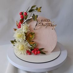 a birthday cake decorated with flowers and leaves