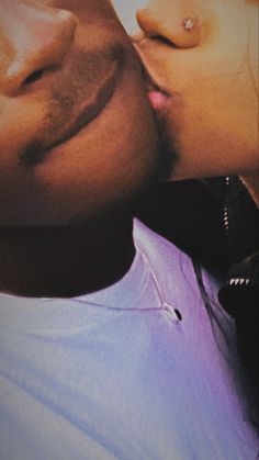 a close up of a person kissing another person