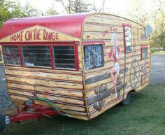 the trailer is made out of wood and has an advertisement painted on it's side