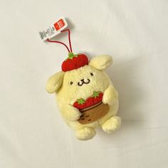 a small stuffed animal with a strawberry on it's head hanging from a string