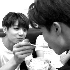 two young men are eating food together