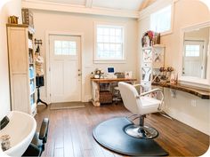 a chair that is sitting in the middle of a room with a desk and mirror