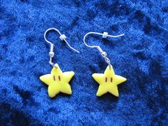 CATCH IT! IT WILL MAKE ME INVINCIBLE!  Well, no. Not really. But you'll feel pretty awesome walking around wearing them anyway. Particularly if someone notices that yes, indeed, you do actually have Super Stars dangling from your ears. Useful if those nasty Koopas invade. You can never be too prepared, after all.  Polymer clay Super Stars on sterling-plated surgical steel ear wires. Painted with an iridescent lacquer, so they shimmer a subtle pinkish colour at certain angles. Star Wars Polymer Clay Earrings, Pokemon Polymer Clay Earrings, Kirby Earrings Clay, Kirby Earrings, Star Polymer Clay, Yellow Star Earrings, Super Star, Feel Pretty, Pretty Cool