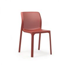 a red plastic chair with a holed design on the back and seat, against a white background