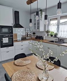 an image of a kitchen setting with flowers in vases on the dining room table