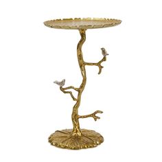 a gold plate with two birds perched on the branches and one bird sitting on the branch