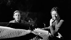 black and white photograph of two people sitting at a table with papers in front of them