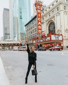 a woman standing in front of the chicago theatre