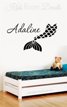 a child's room with a bed and wall decal