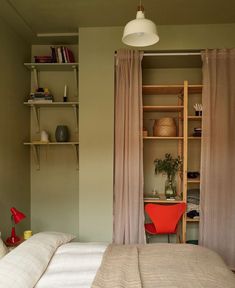 a bed sitting next to a book shelf filled with books