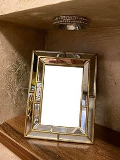 a mirror sitting on top of a wooden shelf