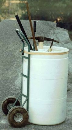 a large white barrel sitting on top of a cement floor next to a hand truck