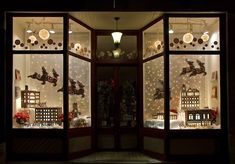 an open window with christmas decorations on display in the front and side windows at night