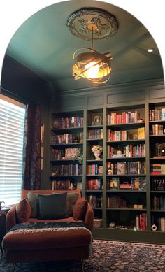 a living room filled with lots of furniture and bookshelves covered in bookcases