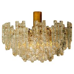 a large chandelier made out of glass and gold colored metal rods with lights on each end