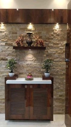 a stone wall with shelves and plants on the top, along with two potted plants