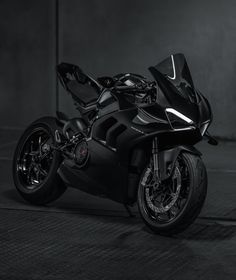 a black motorcycle parked in a dark room