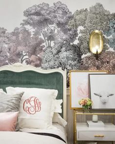 a bedroom with a green headboard and floral wallpaper on the walls behind it