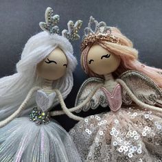 two dolls are dressed in white and silver