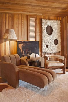 a living room filled with furniture and wooden walls