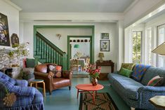 a living room filled with furniture and a fire place under a stair bannister