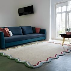 a living room with a blue couch and white rug