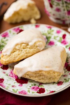 two scones with icing on a floral plate