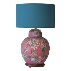 a pink and blue vase with a green lamp on the bottom is sitting in front of a white background