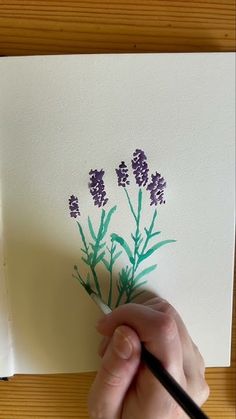 a person is drawing flowers on a piece of paper