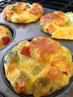 four muffins with different toppings sitting in an oven