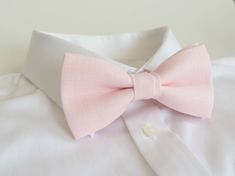 a pink bow tie sitting on top of a white shirt