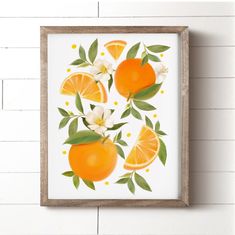 an orange print hangs on the wall next to a white brick wall with flowers and leaves