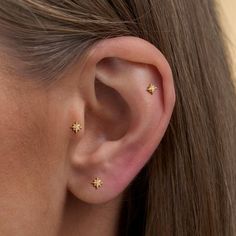 a woman's ear with three small stars on it