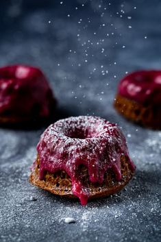 powdered sugar sprinkled on top of a donut with red icing