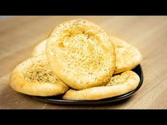 three pieces of bread sitting on top of a black plate with sprinkles