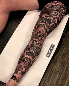 a person with a tattoo on their arm and leg is sitting in front of a table