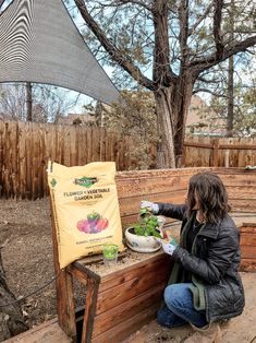 a woman sitting on a wooden bench next to a bag of lettuce seed