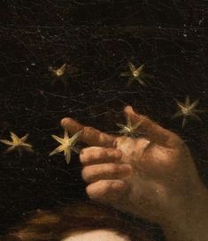 a close up of a person's hand holding stars