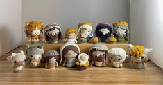 a group of crocheted dolls sitting on top of a wooden table next to each other