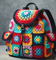 a multicolored crocheted backpack sitting on top of a table