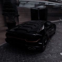 a black sports car parked in front of a building